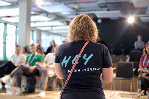 A woman gives a lecture to several people.